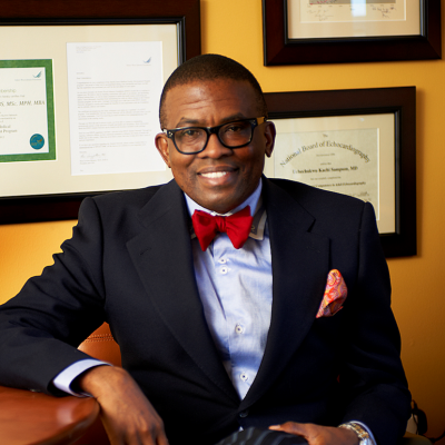 A man in a bowtie posing for a photo in his office